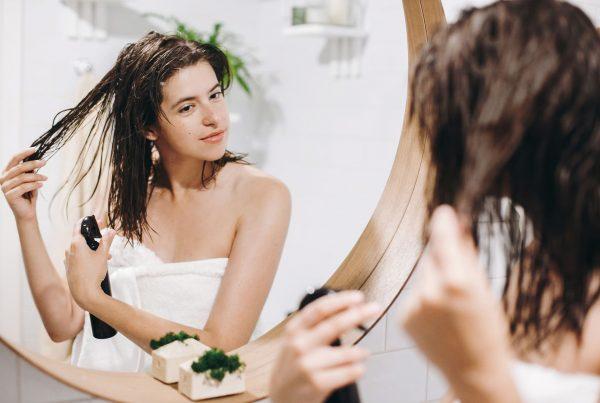 woman conditioning her hair with product from her at-home haircare kit