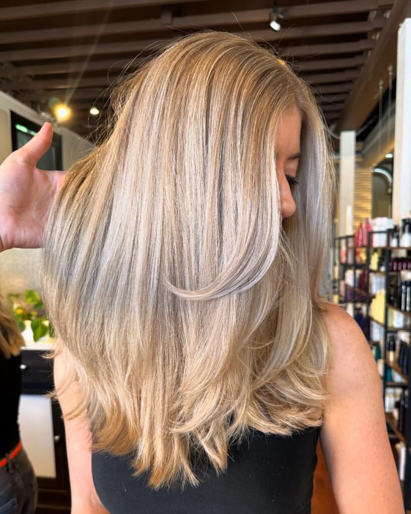 Blonde layered hair after a Fusio Dose deep conditioning treatment, showing soft volume and shine.