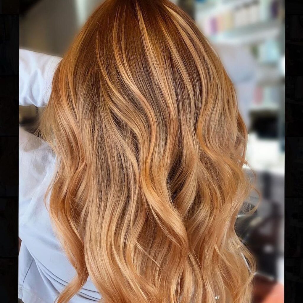 Back view of wavy copper hair after a haircut and blowout styling.