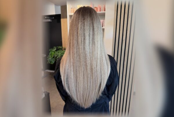 Back view of long blonde hair with a smooth, glossy finish after a hair smoothing service at Deseo Salon & BlowDry in Denver